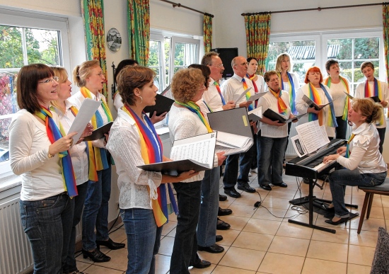 Mit Schals in Regenbogenfarben und frischem Gesang startet der Chor "Alive Vocals"